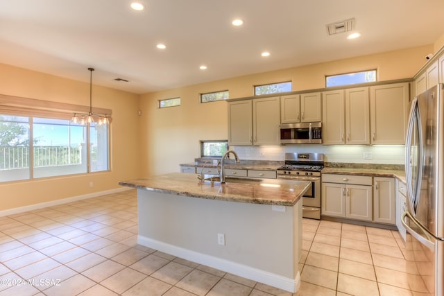 kitchen with pendant lighting, an island with sink, stainless steel appliances, and light tile patterned flooring