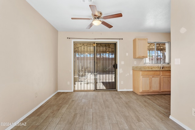 interior space featuring sink, ceiling fan, and light hardwood / wood-style flooring