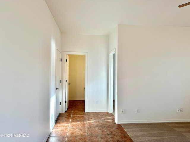 tiled spare room with ceiling fan