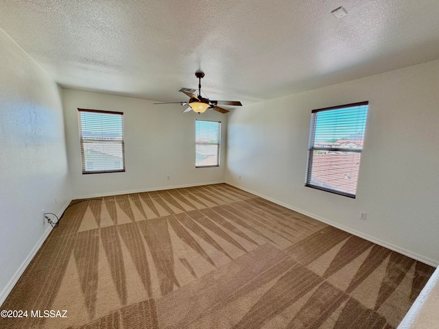 spare room featuring ceiling fan, a textured ceiling, and carpet floors