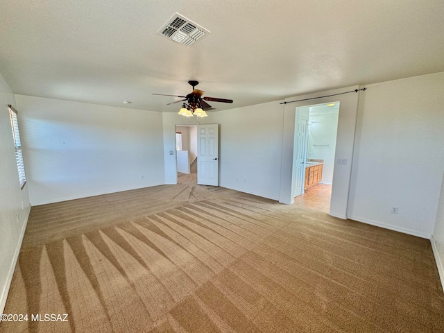 carpeted empty room featuring a textured ceiling and ceiling fan