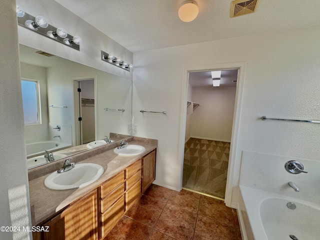 bathroom with vanity, a textured ceiling, separate shower and tub, and tile patterned flooring