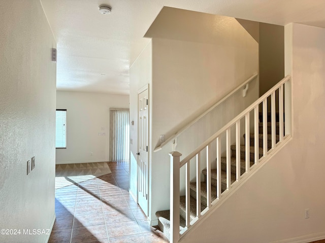 stairway with tile patterned floors