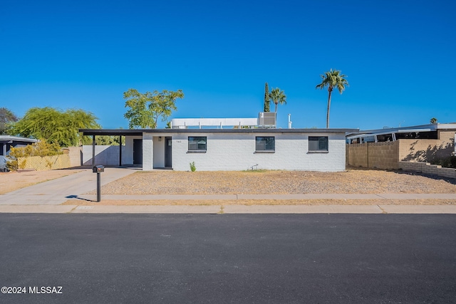 view of front of house featuring central AC and a carport