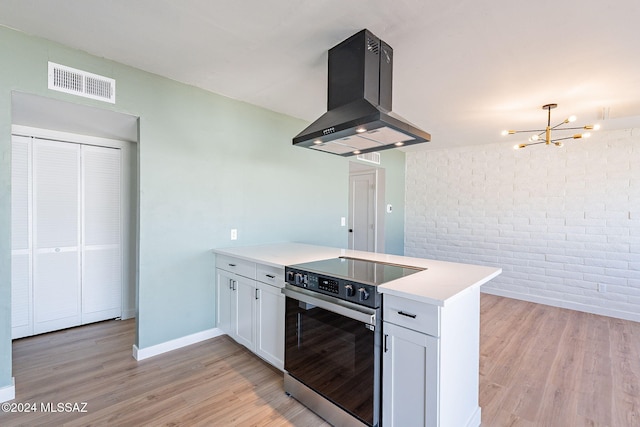 kitchen featuring white cabinetry, electric stove, extractor fan, and light hardwood / wood-style floors