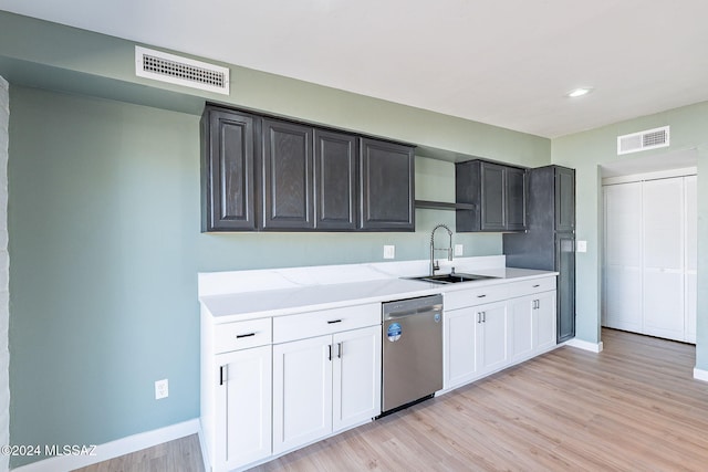 kitchen with dishwasher, white cabinets, sink, and light wood-type flooring