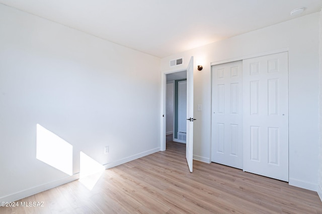 unfurnished bedroom featuring a closet and light hardwood / wood-style floors