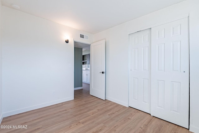 unfurnished bedroom featuring a closet and light hardwood / wood-style floors