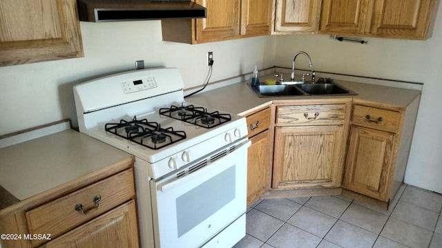 kitchen featuring white gas range, sink, and light tile patterned floors