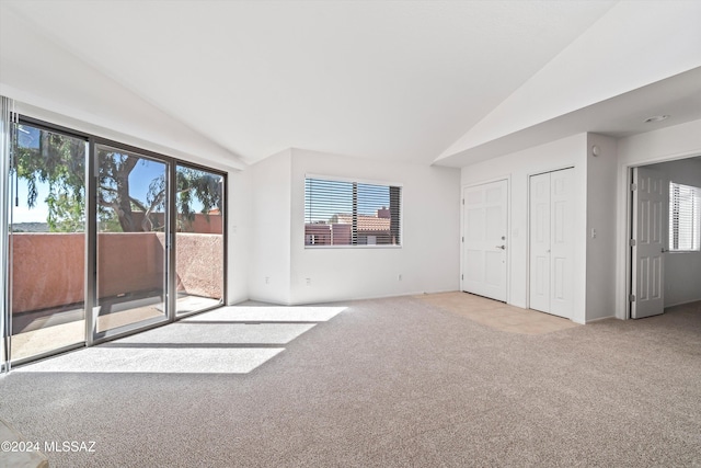 interior space featuring light carpet and vaulted ceiling