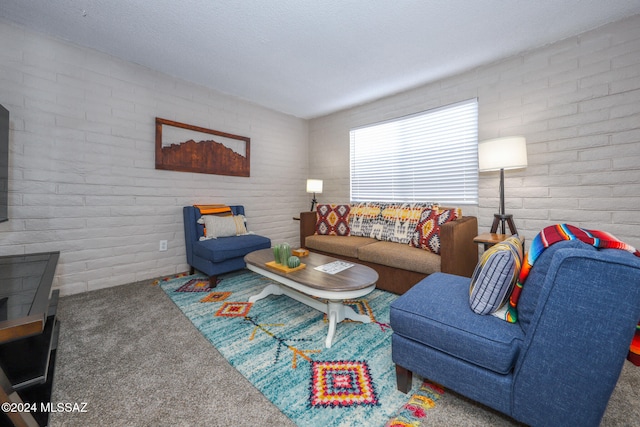 carpeted living room with brick wall and a textured ceiling