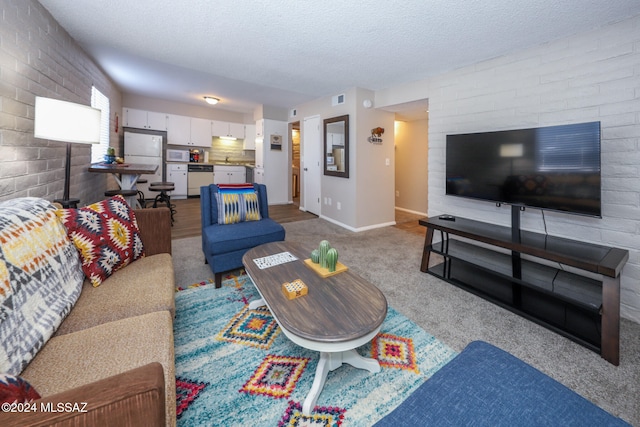 carpeted living room with brick wall and a textured ceiling