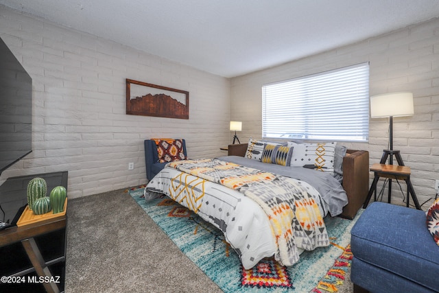 bedroom featuring carpet floors and brick wall