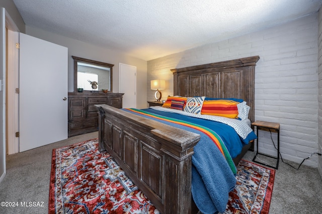 carpeted bedroom featuring brick wall and a textured ceiling