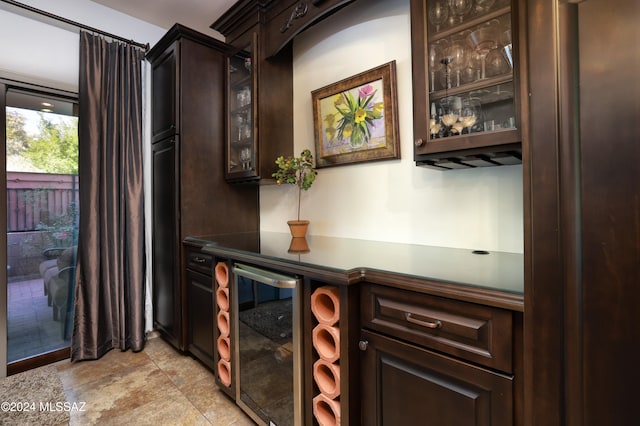 bar with dark brown cabinetry and beverage cooler