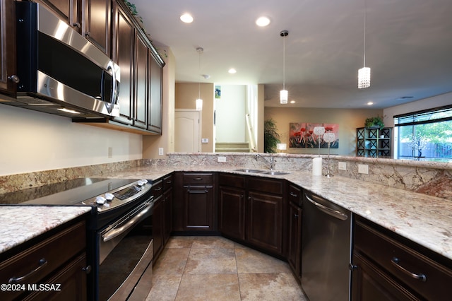 kitchen with dark brown cabinets, stainless steel appliances, sink, pendant lighting, and light stone counters