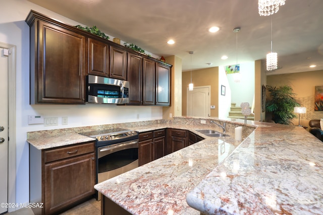 kitchen featuring stainless steel appliances, sink, dark brown cabinetry, pendant lighting, and light stone counters