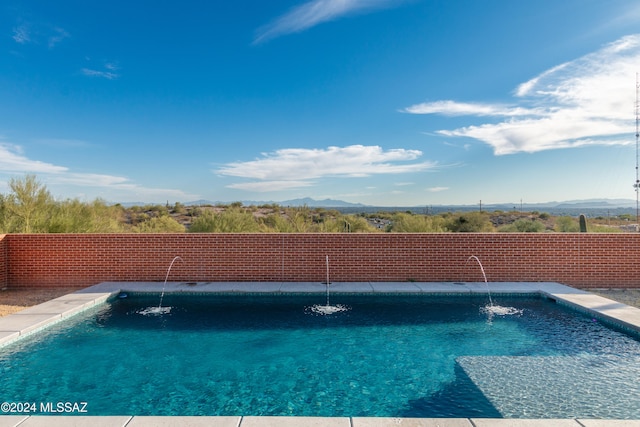 view of swimming pool featuring pool water feature and a mountain view