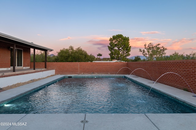 pool at dusk with pool water feature