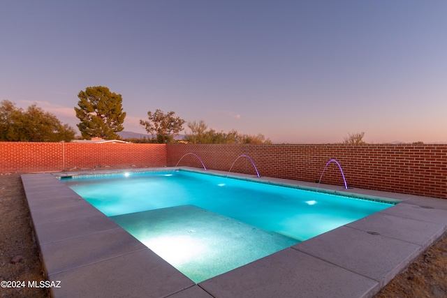 pool at dusk with pool water feature