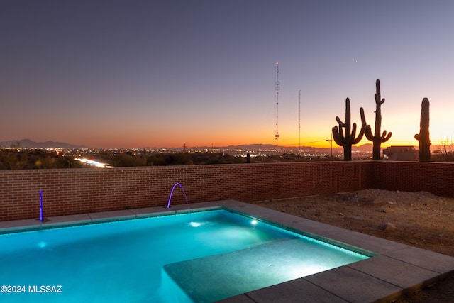 pool at dusk with pool water feature