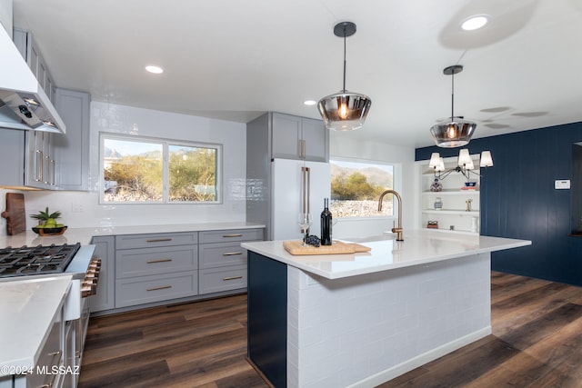 kitchen with high end stove, dark wood-type flooring, wall chimney range hood, and white refrigerator