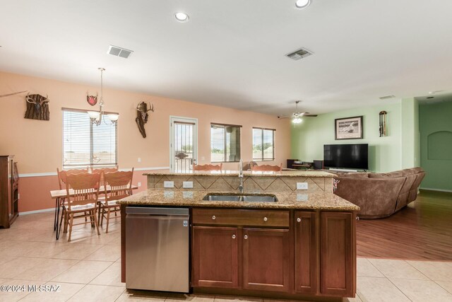 kitchen featuring appliances with stainless steel finishes, decorative backsplash, light stone counters, and a kitchen island