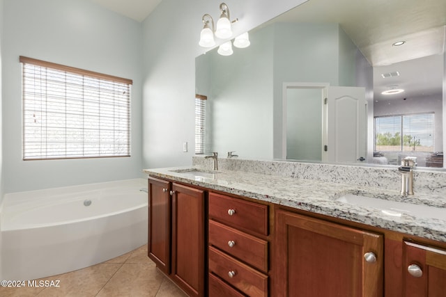 bathroom with an inviting chandelier, vanity, a tub, and tile patterned flooring