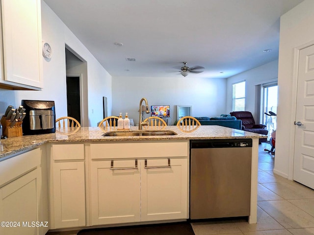 kitchen with dishwasher, kitchen peninsula, sink, light stone countertops, and white cabinets