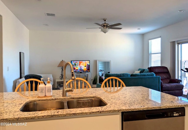 kitchen featuring light stone countertops, stainless steel dishwasher, sink, and ceiling fan