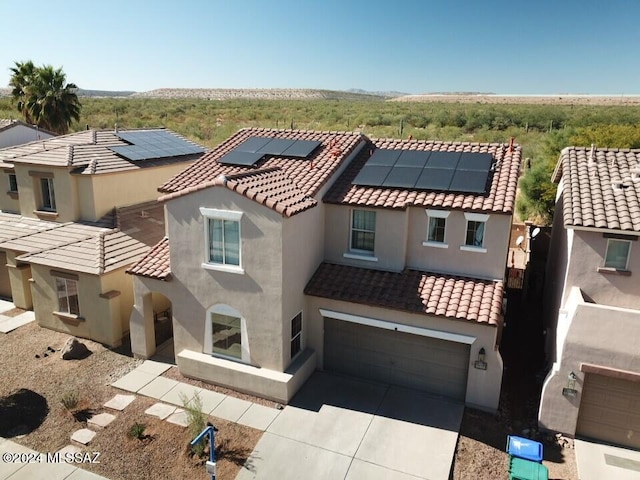 view of front of home featuring solar panels and a garage