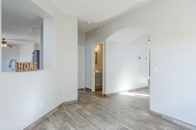 spare room featuring sink, ceiling fan, and light hardwood / wood-style flooring