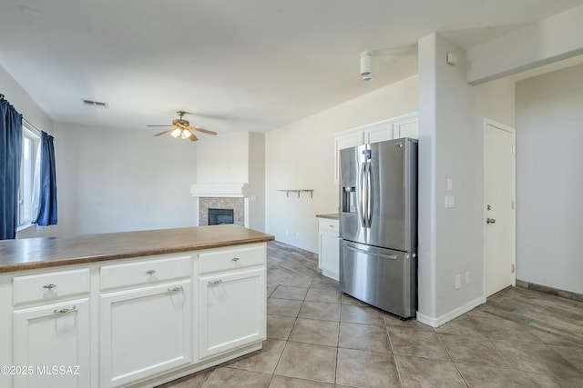 kitchen featuring a tile fireplace, white cabinetry, and stainless steel fridge with ice dispenser