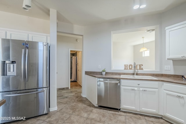 kitchen with hanging light fixtures, appliances with stainless steel finishes, sink, and white cabinets