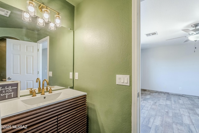 bathroom with ceiling fan, vanity, and hardwood / wood-style floors