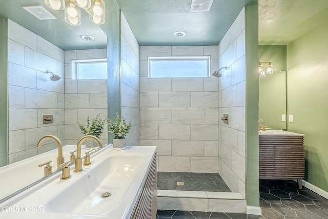 bathroom featuring tiled shower, vanity, and a wealth of natural light