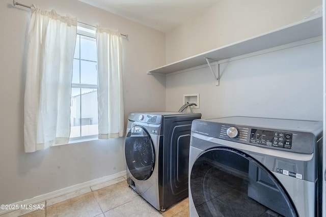 clothes washing area featuring separate washer and dryer and light tile patterned floors