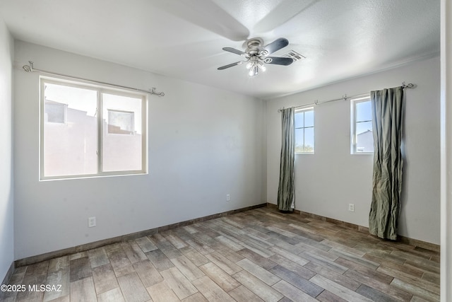 spare room with ceiling fan and light wood-type flooring