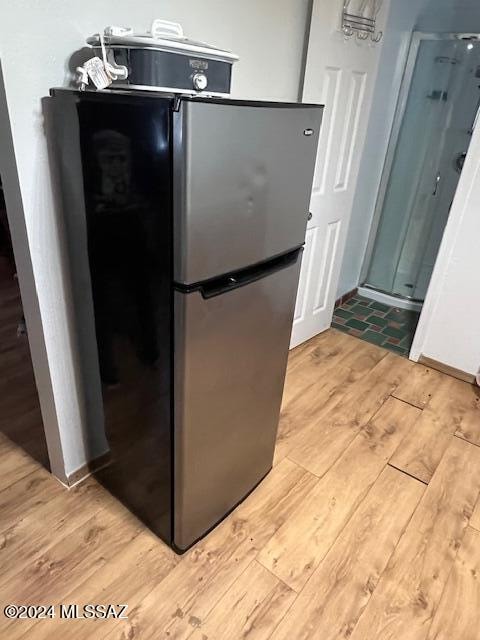 kitchen with light wood-type flooring and stainless steel refrigerator