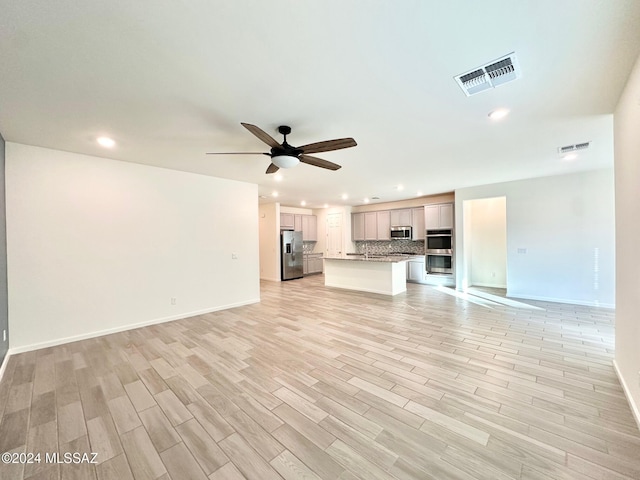 unfurnished living room featuring ceiling fan and light hardwood / wood-style flooring