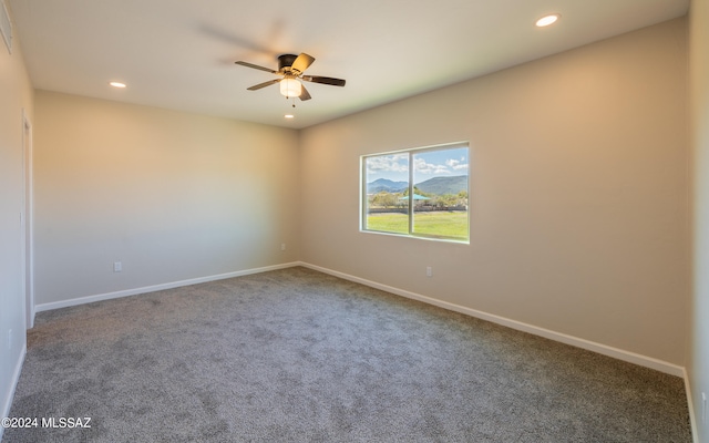 carpeted spare room with ceiling fan