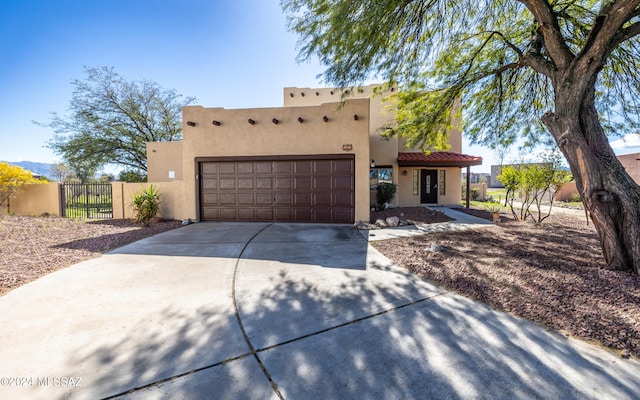 pueblo-style home featuring a garage