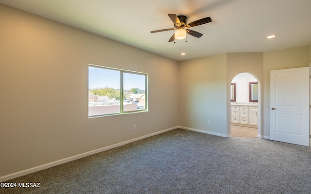 unfurnished bedroom featuring connected bathroom, carpet floors, and ceiling fan