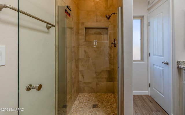 bathroom featuring a shower with door, wood-type flooring, and vanity