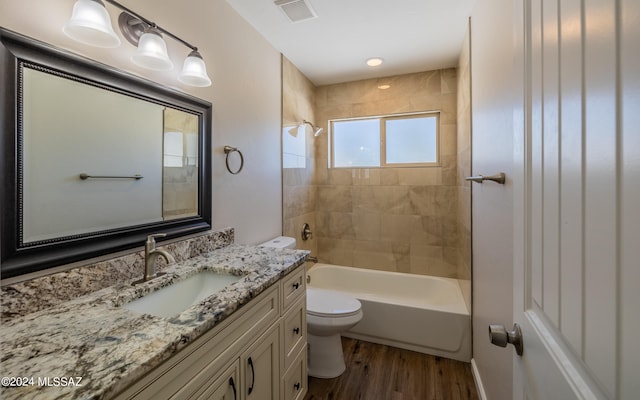 full bathroom with toilet, tiled shower / bath combo, hardwood / wood-style flooring, and vanity