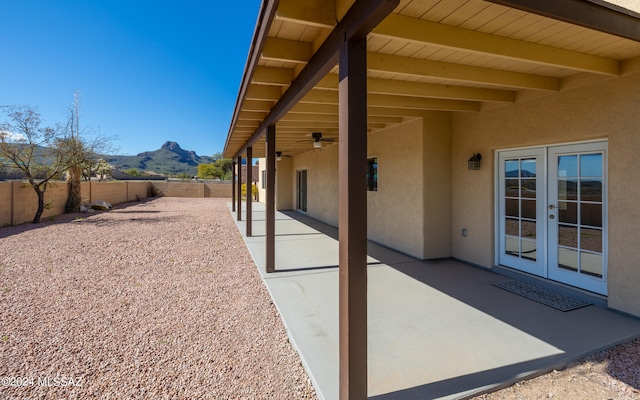 view of patio / terrace with french doors, a mountain view, and ceiling fan