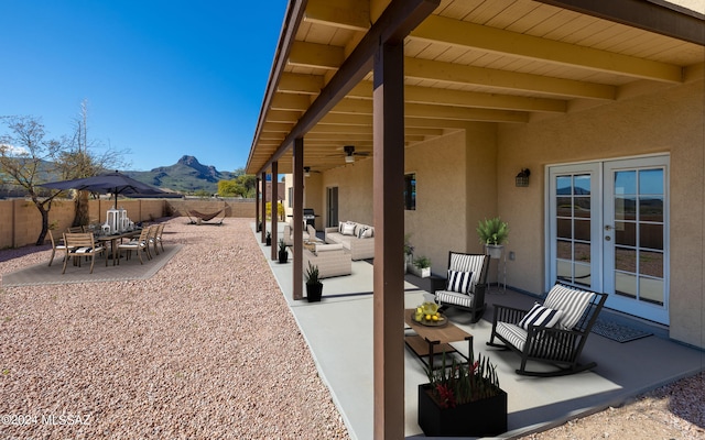 view of patio / terrace featuring an outdoor living space, a mountain view, and ceiling fan