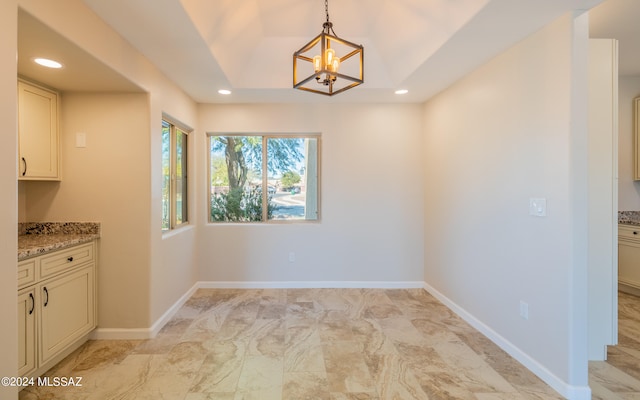 unfurnished dining area with a chandelier