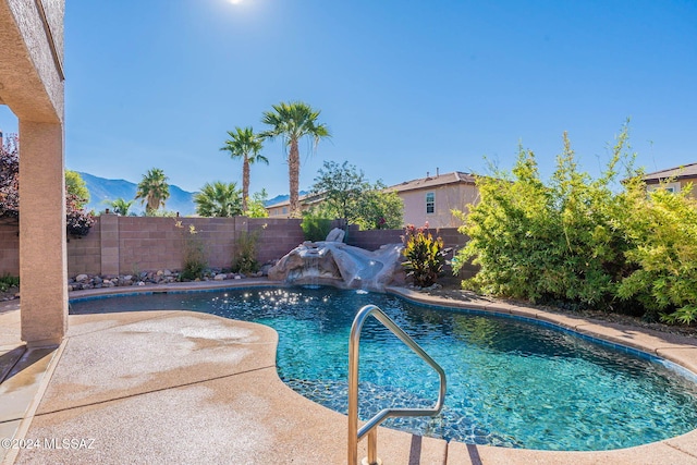 view of pool featuring a patio area, a fenced backyard, a mountain view, and a fenced in pool