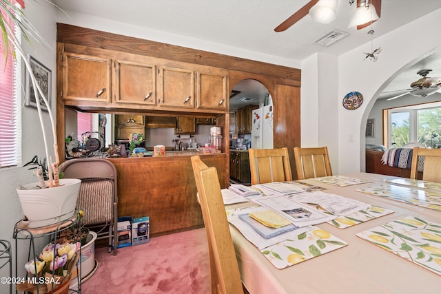 carpeted dining room featuring ceiling fan